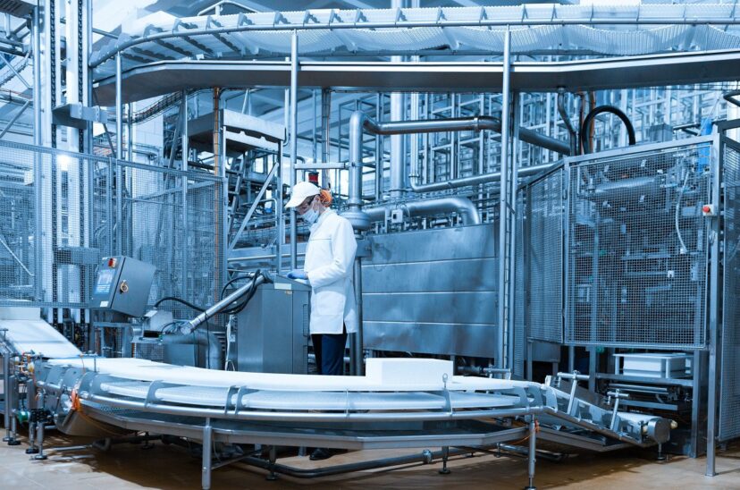 man in a white robe and a cap make an inspection of the production line