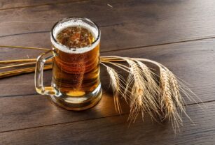 cerveza-taza-vidrio-espigas-alto-angulo-vision-sobre-mesa-madera