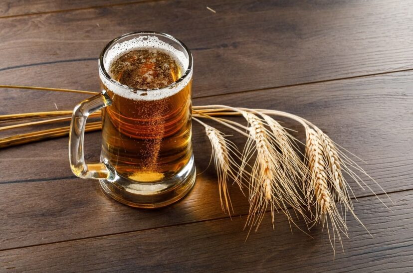 cerveza-taza-vidrio-espigas-alto-angulo-vision-sobre-mesa-madera